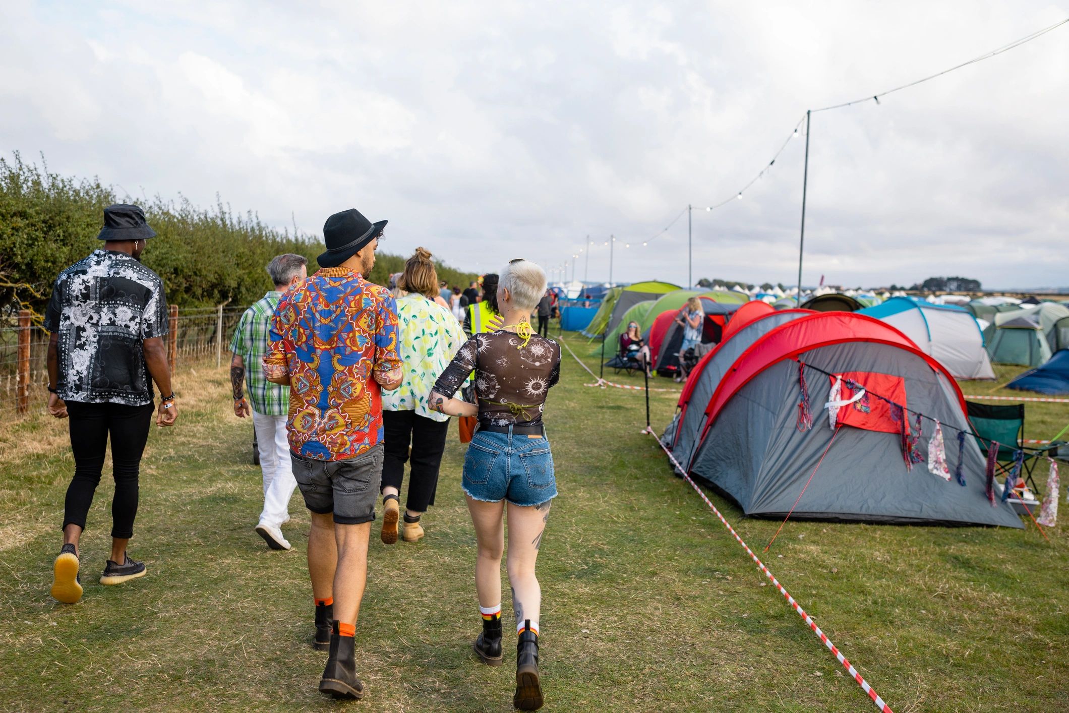 Festivalgoers walking together toward live music at an outdoor event